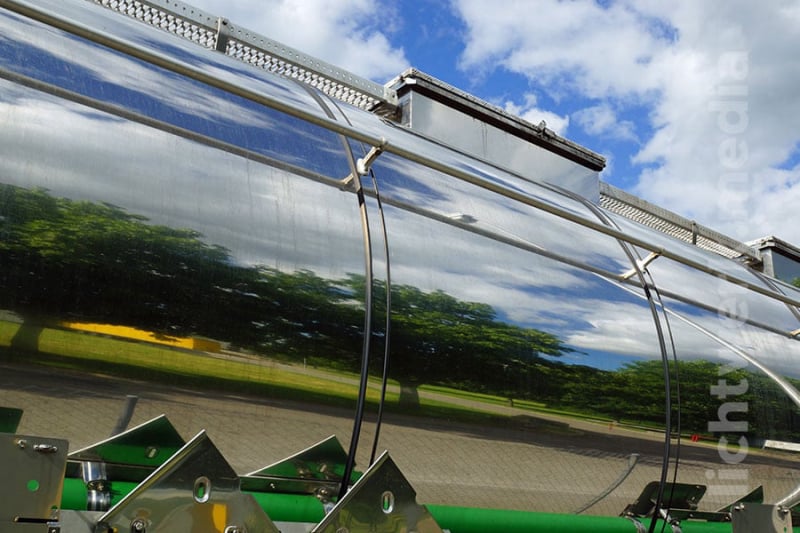 landschaft (bäume, wiese) spiegelt sich in poliertem tank eines tanklasters