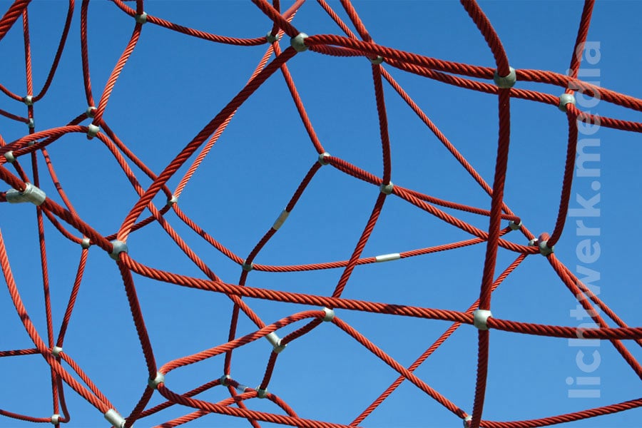 rote seile, kreuz und quer durcheinander gespannt, vor blauem himmel