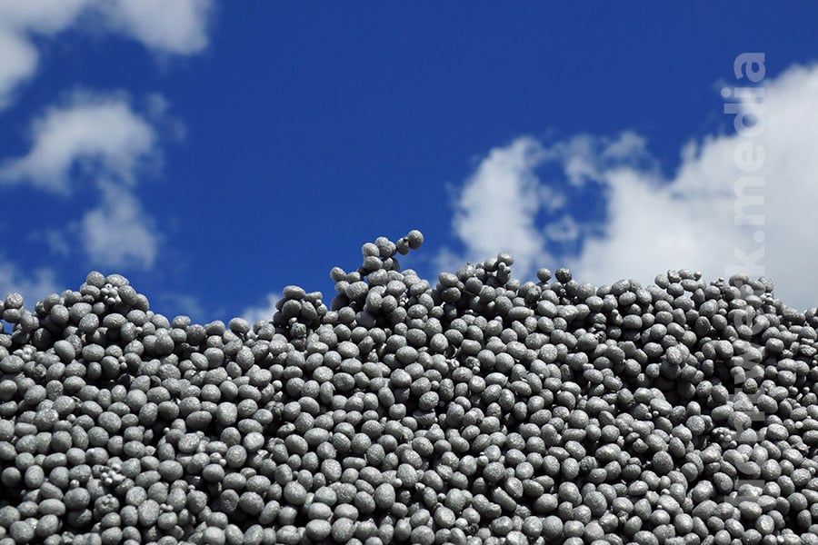zur wand aufgetürmte styroporkugeln vor blauem himmel