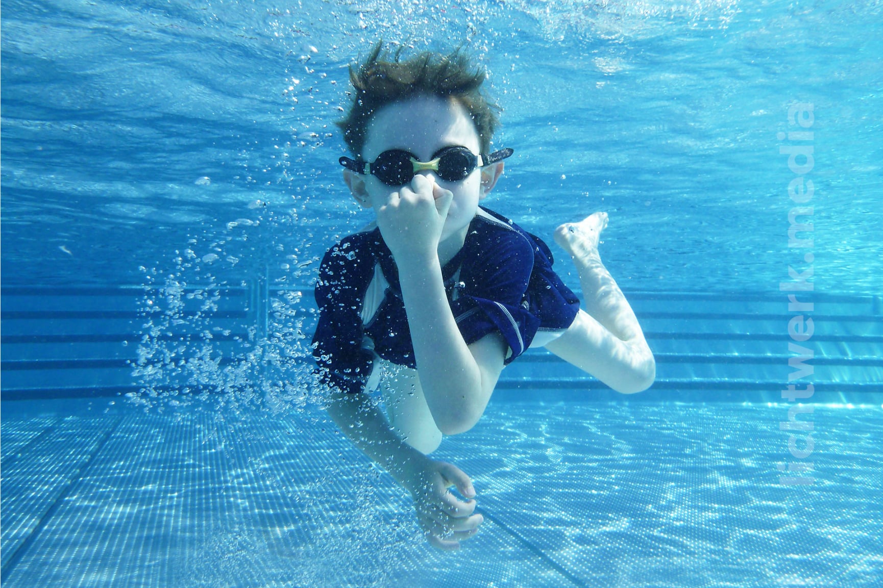 im schwimmbad tauchender junge